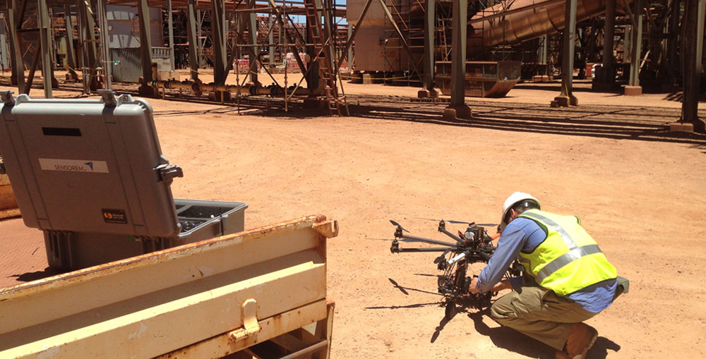 Sensorem staff member setting up drone on a construction site.